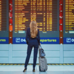 Airport-woman-standing-in-front-of-flight-board